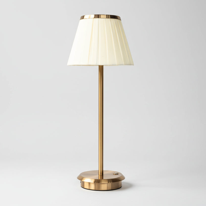 Grande lampe à poser élégante avec pied fin en laiton doré et abat-jour plissé de couleur crème, luminaire sophistiqué pour buffet, console ou décoration d'intérieur classique moderne.