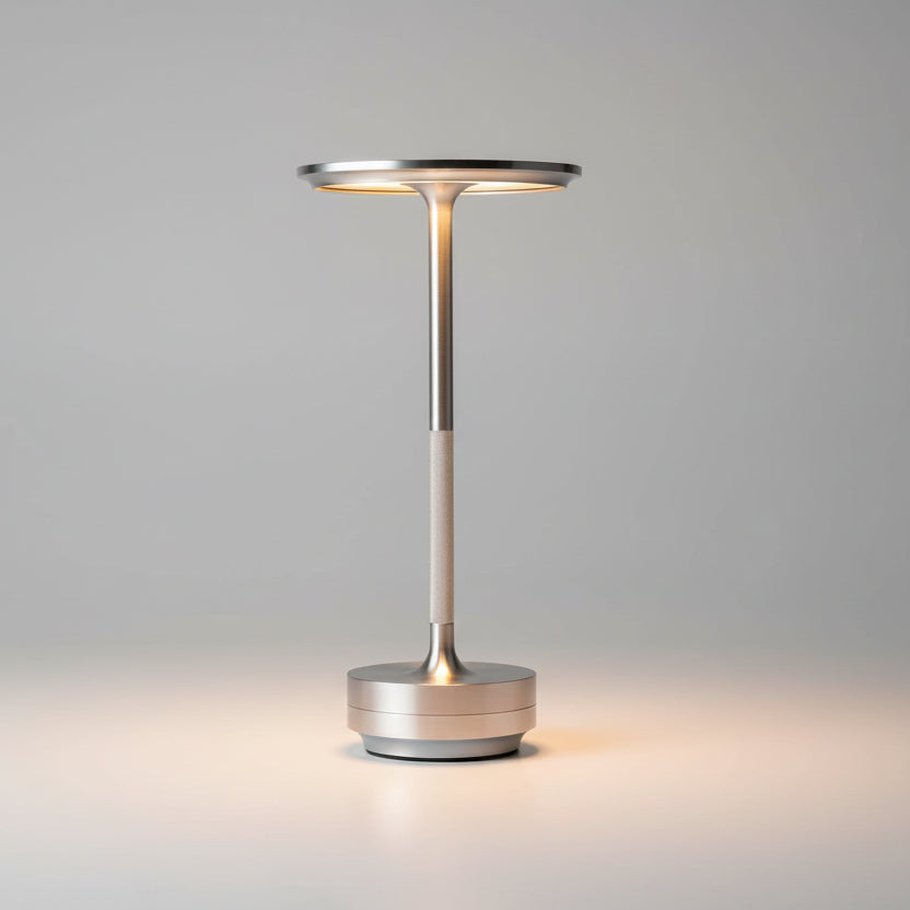 Lampe de table LED rechargeable sans fil en laiton argent avec tête ultra-plate circulaire, design minimaliste et élégant pour un éclairage de bureau ou de restaurant haut de gamme.