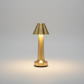 Lampe de table LED rechargeable sans fil en métal doré brossé, dotée d'un abat-jour conique et d'un pied cylindrique évasé, luminaire d'appoint design pour restaurant ou table de chevet.