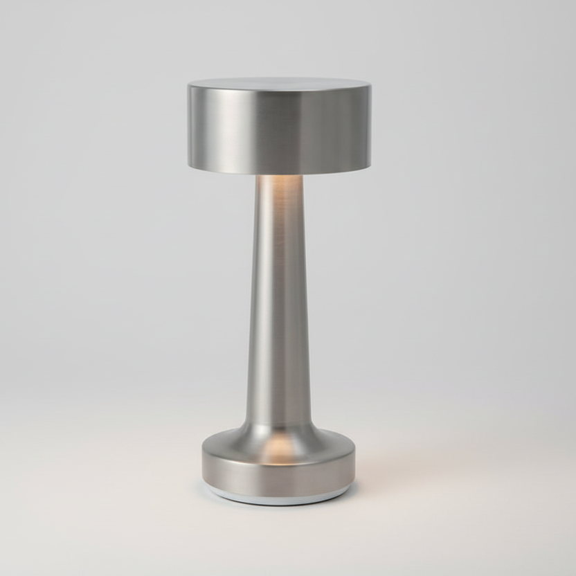 Lampe de table LED rechargeable sans fil en laiton gris brossé avec abat-jour cylindrique et pied évasé, luminaire d'appoint moderne pour restaurant, hôtel ou décoration de salon.